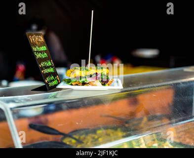Patacon Sandwich - Traditionelles Sandwich aus Kochbananen (Kochbananen) mit Hühnerfleisch und Salat. Frisch zubereitet am Food Truck. Afrikanisches f Stockfoto