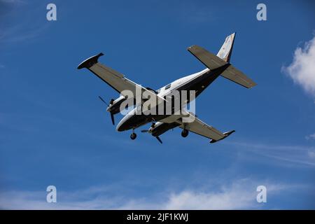 Ein kleines Flugzeug fliegt am sonnigen Sommertag über den Himmel Stockfoto