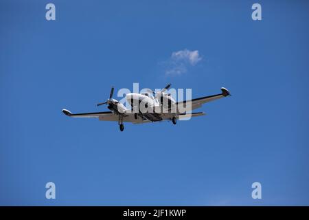 Ein kleines Flugzeug fliegt am sonnigen Sommertag über den Himmel Stockfoto