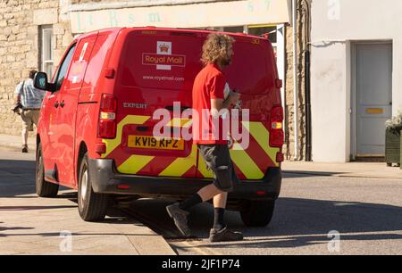 St Just, Cornwall, England, Großbritannien. 2022. Royal Mail Red van und Postbote arbeiten in dieser berühmten kornischen Stadt, Großbritannien. Stockfoto