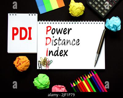 PDI-Leistungsindex. Concept Words PDI Power distance Index auf weißer Note auf einem schönen schwarzen Hintergrund. Rechner und Stift. Sachschaden Stockfoto