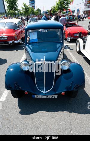 Ostrava, Tschechien - 06.05.2022: Hochwinklige, vertikale Frontalaufnahme des blauen Tatra 57A-Oldtimer. Menschen bewundern Retro-Autos während Veteranen Rallye Stockfoto