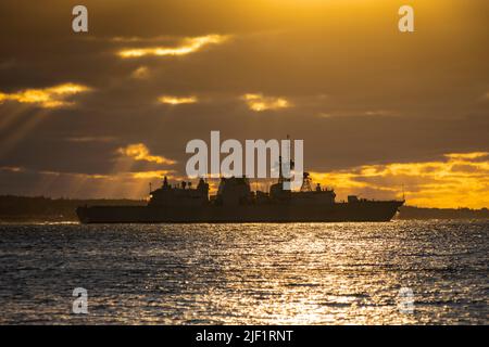 Die Halifax-Klasse der Royal Canadian Navy HMCS Montreal, die gegen den Sonnenaufgang silhouettiert wurde, verlässt Halifax Harbour, Nova Scotia, Kanada. Stockfoto