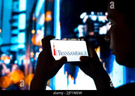 Brasilien. 28.. Juni 2022. In dieser Abbildung hält eine Frau mit Silhouetten ein Smartphone mit dem Transamerica Corporation-Logo auf dem Bildschirm. (Bild: © Rafael Henrique/SOPA Images via ZUMA Press Wire) Stockfoto