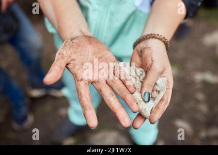 Nahaufnahme einer nicht erkennbaren Frau mit antibakteriellen Feuchttüchern, um die Hände im Freien zu reinigen und zu desinfizieren. Nahaufnahme der weiblichen Wischhände wi Stockfoto