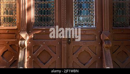 Alte braune Vintage-Türen mit Buntglasfenstern. Stockfoto