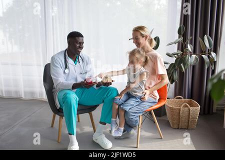 Mutter und kleine Tochter bei einem afroamerikanischen Arzttermin. Richtige Ernährung Stockfoto