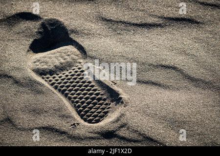 Ein Fußabdruck auf einem Strand im Sand. Stockfoto