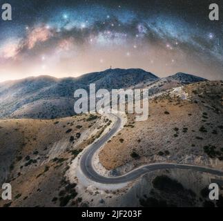 Milky Way Bogen und gewundene Bergstraße in der Nacht Stockfoto