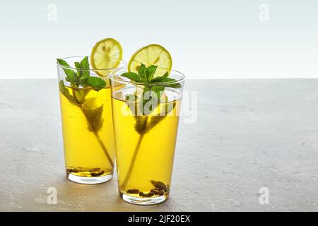 Zwei Tassen hausgemachter, fermentierter Kombucha-Tee sind mit Minze und Zitrone dekoriert Stockfoto