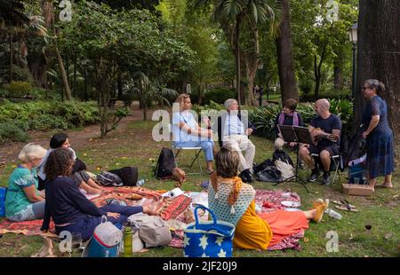 Eine Gruppe von Leuten, die in einem Lissabonner Park ein Picknick machen und Musik spielen Stockfoto