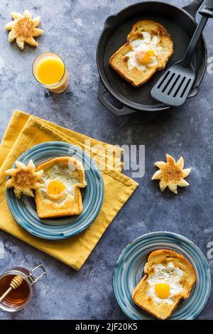 Sonnenschein Toast mit gebratenem Ei in der Mitte in einer Pfanne und auf Tellern. Stockfoto