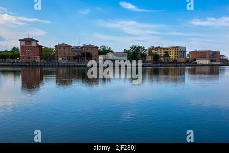 Ravenna, Italien: 10-04-2022: Wunderschöne Gebäude spiegeln sich an einem sonnigen Morgen auf Ravenna's darsena. Ein Dock ist ein abgetrennter Bereich mit Wasser, für den verwendet wird Stockfoto