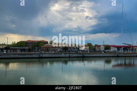 Ravenna, Italien: 10-04-2022: Wunderschöne Gebäude spiegeln sich an einem sonnigen Morgen auf Ravenna's darsena. Ein Dock ist ein abgetrennter Bereich mit Wasser, für den verwendet wird Stockfoto