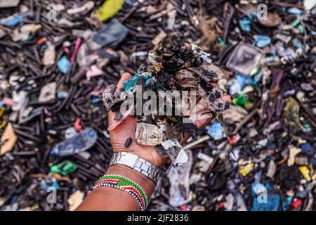 Mombasa, Kenia. 26.. Juni 2022. Man sieht die Hand eines Mannes, der Plastikmüll hält, der am Ufer in der Altstadt von Lamu gesammelt wurde. Die Verschmutzung durch menschliche Aktivitäten hat die Ozeane negativ beeinflusst. Der kenianische Präsident Uhuru Kenyatta sagte in seiner Rede während der laufenden Ozeankonferenz in Lissabon, Portugal, dass die Plastikverschmutzung mindestens 700 Arten von Meereslebewesen krank macht und kontaminiert, und forderte dringende globale Maßnahmen zum Schutz unserer Ozeane. Die Ozeankonferenz wird von den Regierungen Portugals und Kenias gemeinsam ausgerichtet. Kredit: SOPA Images Limited/Alamy Live Nachrichten Stockfoto