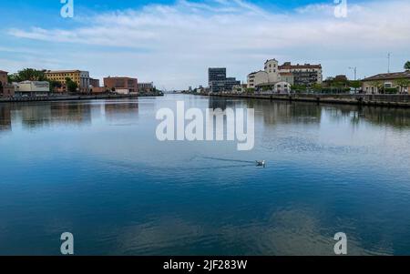 Ravenna, Italien: 10-04-2022: Wunderschöne Gebäude spiegeln sich an einem sonnigen Morgen auf Ravenna's darsena. Ein Dock ist ein abgetrennter Bereich mit Wasser, für den verwendet wird Stockfoto