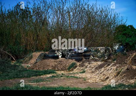 Huliaipole, Region Zaporizhzhia, Ukraine. 7.. Mai 2022. Ukrainischer Checkpoint, der von Bäumen versteckt ist. Ukrainische Soldaten haben ihren Stützpunkt an einem Kontrollpunkt in der Nähe von Huliaipole, Region Zaporizhzhya. Von Zeit zu Zeit kommt es in der Region zu russischen Beschuss-Angriffen. Russische Truppen versuchen, ihre Anstrengungen auf dieses Gebiet zu konzentrieren. Deshalb müssen ukrainische Soldaten immer auf das Schlimmste vorbereitet sein. (Bild: © Lara Hauser/SOPA Images via ZUMA Press Wire) Stockfoto