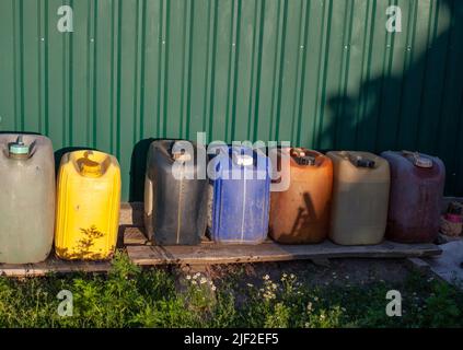 Alte Kraftstoffkanister aus Kunststoff. Vorräte an Dieselkraftstoff auf dem Hof. Kraftstoffmangel im Land Stockfoto