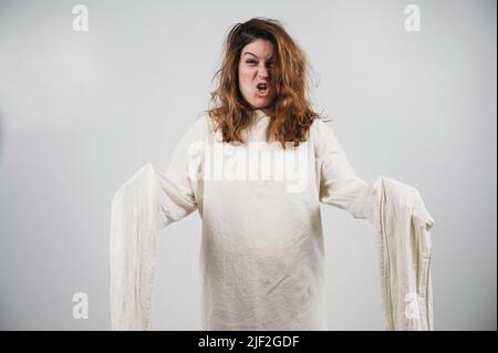 Nahaufnahme Porträt einer verrückten Frau in Zwangsjacke auf weißem Hintergrund. Stockfoto