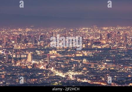 Lichter von Wolkenkratzern und Bürogebäuden in der Innenstadt von Osaka bei Nacht Stockfoto