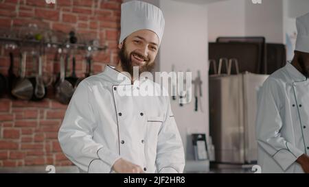 Portrait von männlichen Koch tun Mahlzeit Vorbereitungen für Gourmet-Rezept, mit frischen Sellerie und Bio-Zutaten. Junger Mann bereitet Gastronomie Gericht, um köstliche Mahlzeit in der Restaurantküche zu machen. Stockfoto