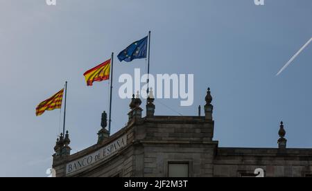 Barcelona, Katalonien, Spanien - 22. Mai 2022: Flaggen von Katalonien, Spanien und der Europäischen Union auf dem Bankgebäude. Das Gebäude der Bank of Spain. Spanisch Stockfoto