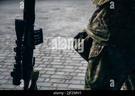 15. Mai 2022, Pokrovskoe, Region Dnepropetrovsk, Ukraine: Soldat mit seiner Waffe vor dem Militärkrankenhaus. Das Militärkrankenhaus in Pokrovskoe, Region Dnepropetrovsk, stabilisiert die Bedingungen der verwundeten Soldaten von der Front aus. Danach werden sie in größere Krankenhäuser in Zaporizhia und Dnipro überführt. Die Regionen Saporischschja und Dnipro sind seit Kriegsbeginn ein Schwerpunkt der russischen Angriffe. (Bild: © Lara Hauser/SOPA Images via ZUMA Press Wire) Stockfoto