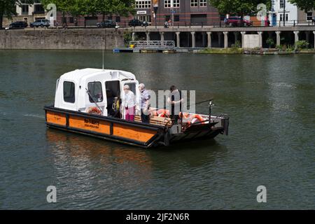 Ein Cross Harbor Ferry Boot mit Touristen an Bord verlangsamt sich in der Nähe der SS Großbritannien, um Fotos zu machen. Stockfoto