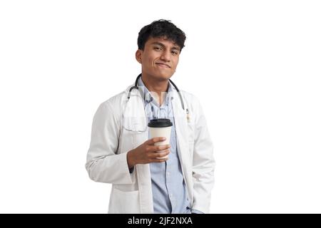 Junger peruanischer Arzt lächelt und schaut isoliert auf die Kamera mit einem Kaffee. Stockfoto