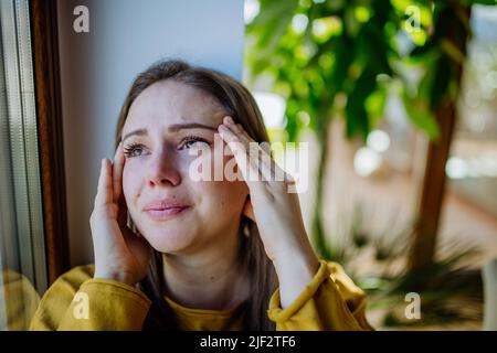 Frau, die an Depressionen leidet und zu Hause weint. Stockfoto