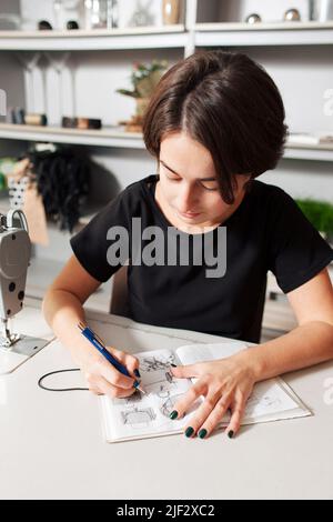 Designer zieht die Kleider und Taschen. Stockfoto