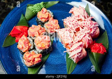 Sushi rollt auf einem blauen Teller. Nahaufnahme, selektiver Fokus Stockfoto
