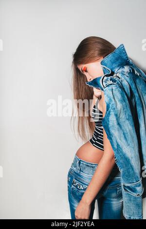 Fashionista in Jeans mit hellem Make-up Stockfoto