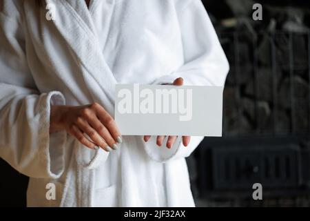 Frau mit Geschenkgutschein für die Spa-Behandlung in der Sauna Stockfoto