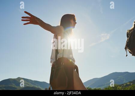 Unbeschwerte junge Frau beim Balancieren und Spazieren während einer Wanderung in der Natur mit einem Freund. Junge Frau genießt eine Wanderung in der Natur mit einem Freund. Glücklich jung Stockfoto