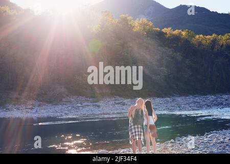 Zwei Frauen an einem Fluss, die bei einer Wanderung in der Natur eine Pause einlegen. Zwei Freunde wandern in der Natur und genießen die Aussicht und machen eine Pause am Fluss Stockfoto