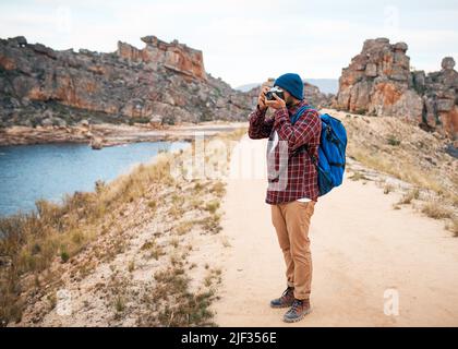 Ein Backpacker fotografiert beim Wandern den Seeblick in den Bergen Stockfoto
