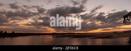 Die Sonnenuntergänge über den südlichen Bergländern und baden den Rufiji River in goldenem Glanz. Der Rufiji ist der größte Fluss Ostafrikas Stockfoto