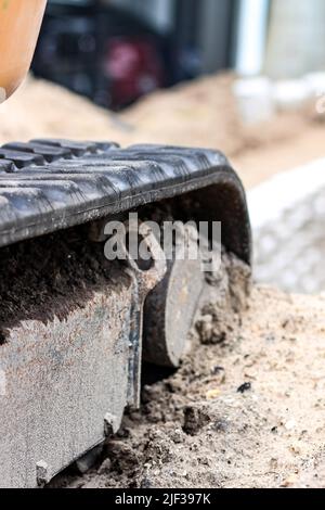 Eine vertikale Aufnahme eines Baggers mit Gummireifen während der Konstruktion Stockfoto