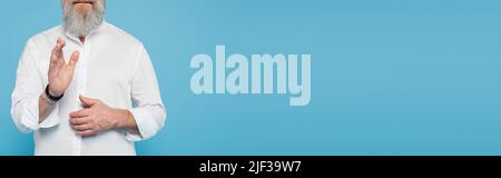 Beschnittene Ansicht von Mastermind Coach in Perlen Armbänder zeigt Segen Geste isoliert auf blauem Banner Stockfoto