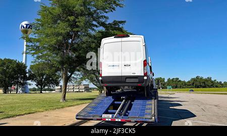 Emporia, KS, USA. 28.. Juni 2022. Neu gebaut im Ford-Montagewerk in Claycomo, Missouri, wird am 28. Juni 2022 ein kommerzieller Lieferwagen von Ford E-Transit auf einen Transporter am Rastplatz Turnpike außerhalb von Emporia, Kansas, verladen. Kredit: Mark Reinstein/Media Punch/Alamy Live Nachrichten Stockfoto