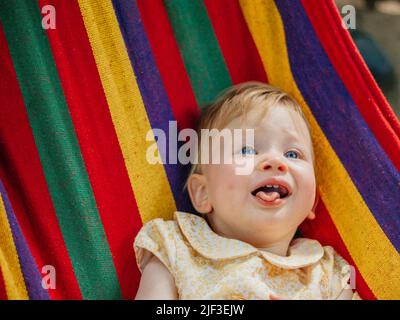 Kind in einer Regenbogenhängematte Stockfoto