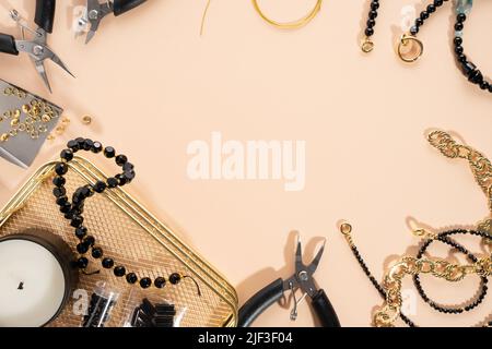 Werkzeuge und Zubehör für DIY-Schmuck am Arbeitsplatz. Kreative flache Lay auf beigem Hintergrund. Flat Lay Konzept Komposition, Draufsicht. Heimwerker-Hobby Stockfoto