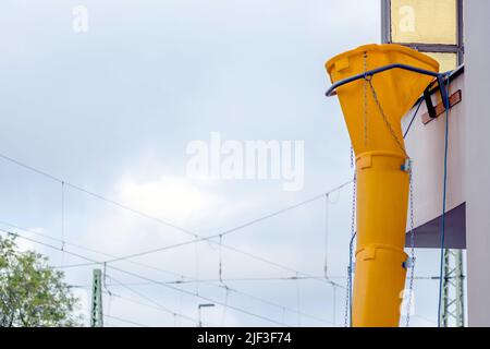 Gelbe Schutthülle oder Schutthülle an der Fassade des alten weißen Hauses helfen bei der Renovierung und Renovierung des alten Grundstücks für saubere Schutthülle Stockfoto