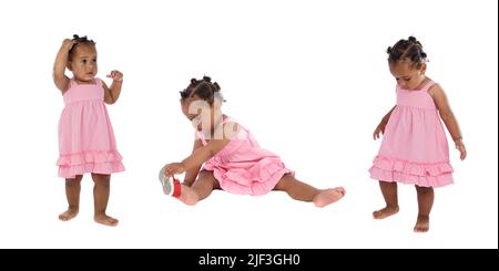Wunderschöne afroamerikanische Drillinge mit pinken Kleidern, die isoliert auf weißem Hintergrund spielen Stockfoto