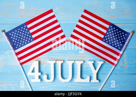 Text des 4. Juli und Flagge der Vereinigten Staaten von Amerika auf Holztisch Hintergrund. USA Unabhängigkeitsfeiertag und Festungskonzepte Stockfoto