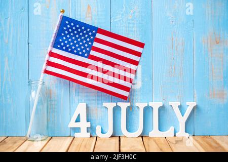 Text des 4. Juli und Flagge der Vereinigten Staaten von Amerika auf Holztisch Hintergrund. USA Unabhängigkeitsfeiertag und Festungskonzepte Stockfoto