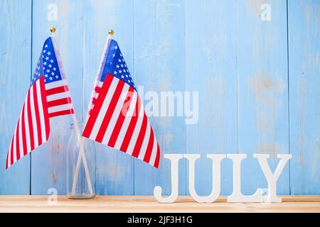 Juli Text und Flagge der Vereinigten Staaten von Amerika auf Holztisch Hintergrund. USA Unabhängigkeitsfeiertag und Festungskonzepte Stockfoto
