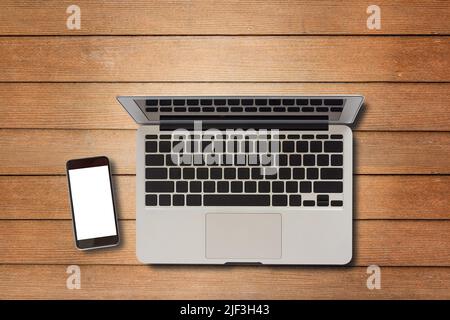 Laptop-Computer und Smartphone auf Holz Tischansicht mit Kopierplatz.Bürobedarf und Gadgets auf Schreibtisch-Tisch.Arbeitstisch-Konzept. Stockfoto