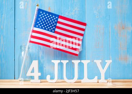 Text des 4. Juli und Flagge der Vereinigten Staaten von Amerika auf Holztisch Hintergrund. USA Unabhängigkeitsfeiertag und Festungskonzepte Stockfoto
